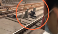 重庆一男子早高峰戴口罩翻栏跳进地铁轨行区 目击者：男子被救起后带走
